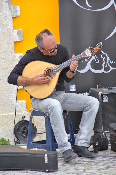 Musician playing the Portuguese guitar, in Sitio square
